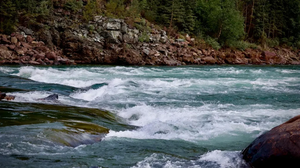 Whitewater rushing through a river canyon at high flow