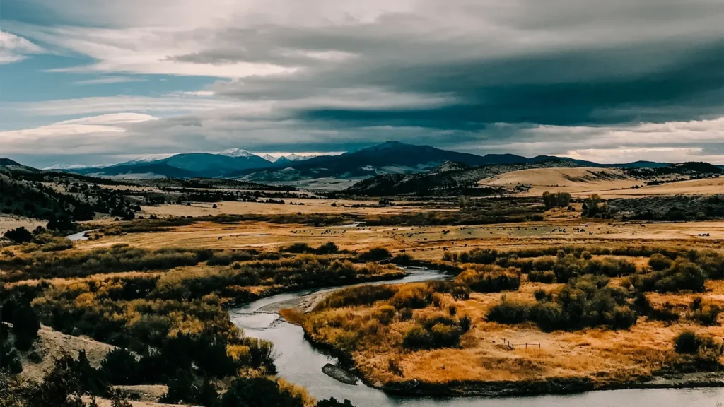 A river meandering through open sage flats under big sky in the Northern Rockies
