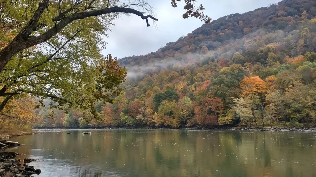 Mist lifting off a river between wooded Appalachian ridges