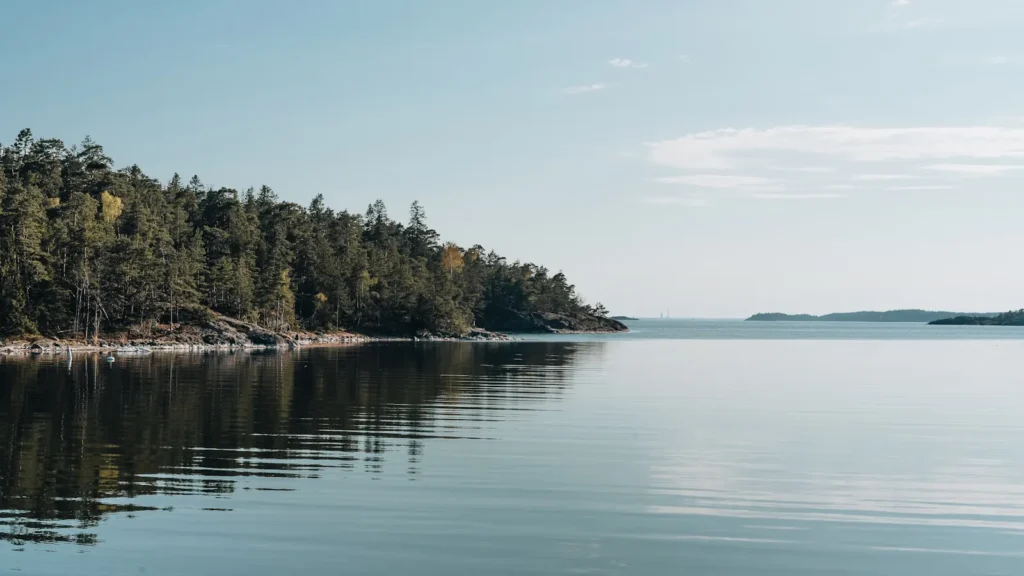 A broad northern lake broken by wooded islands under open sky