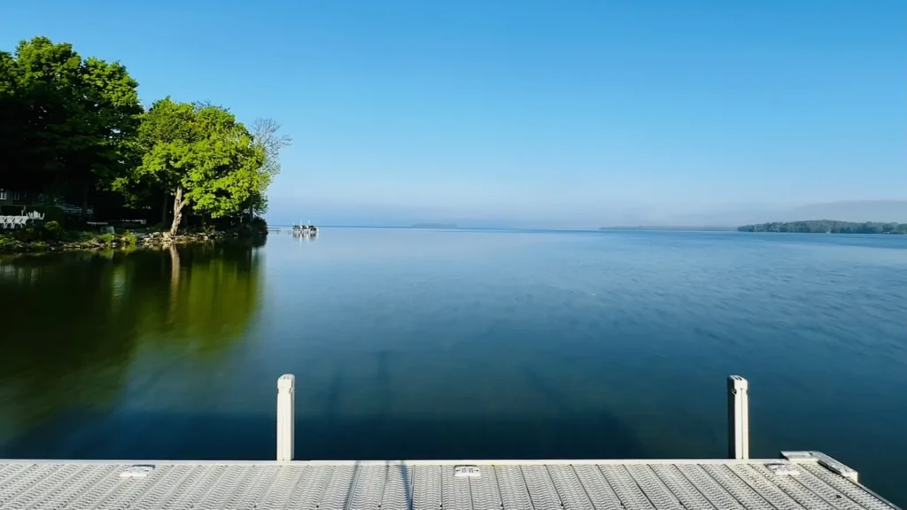 A dock on a broad calm lake edged with timber