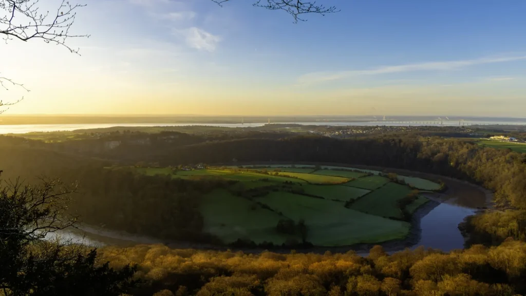 Sunrise over a winding river cutting through open farm country